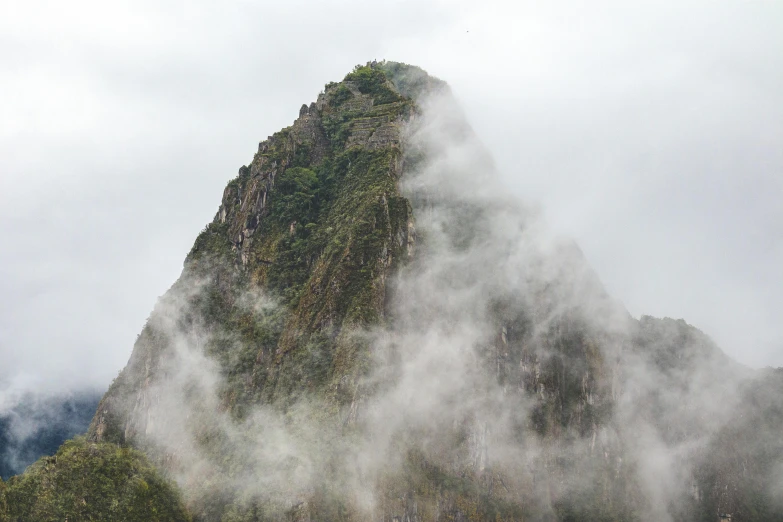 a tall rock sticking up out of the fog