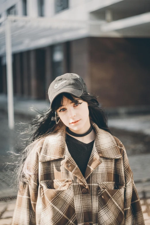 a young woman is standing on the sidewalk