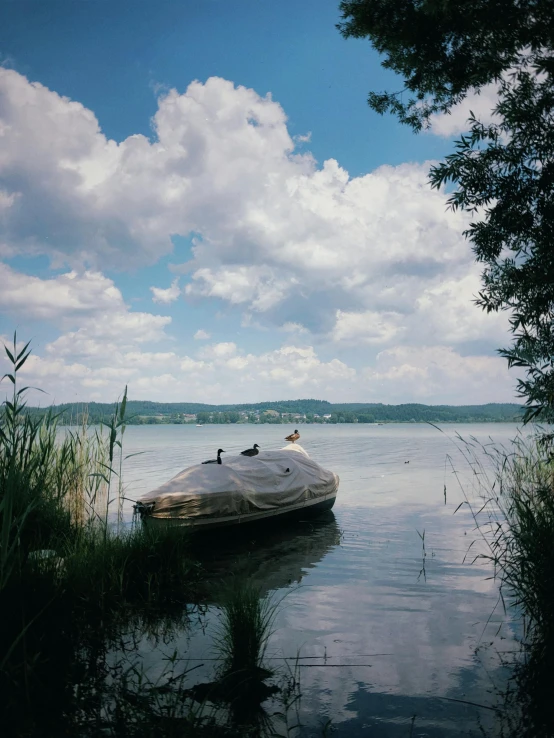 a small boat in the water on a cloudy day