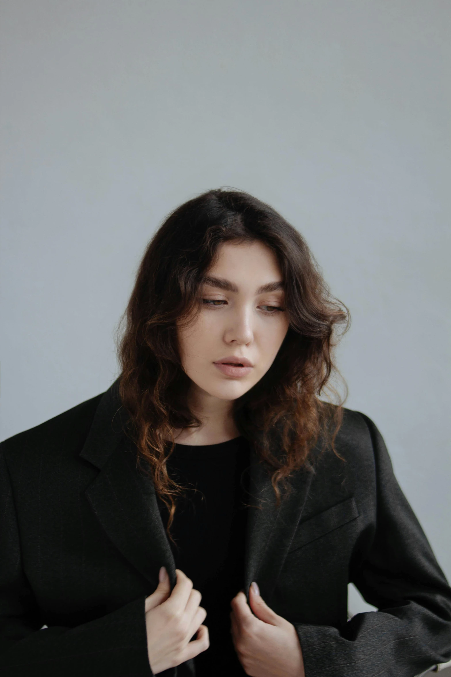 a woman adjusts her suit jacket