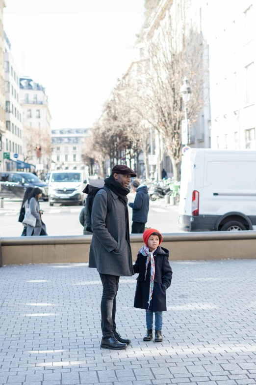 a man and child standing in the middle of a street