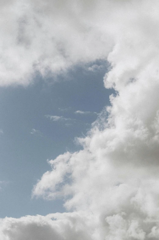 a plane in the air with fluffy clouds