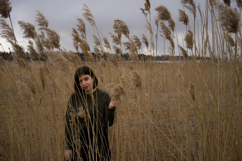 girl in black dress in grassy field with brown grass