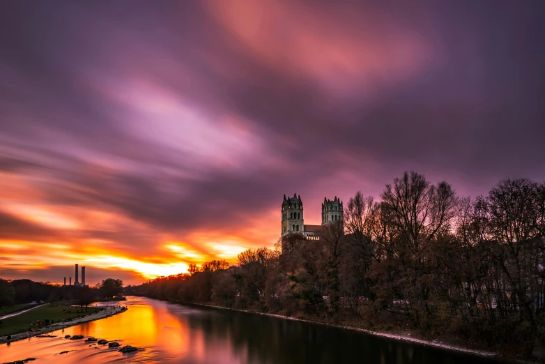 a beautiful sunset on a cloudy day over some buildings