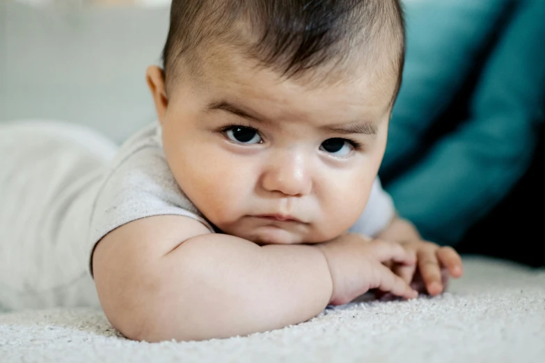 baby laying down with blue eyes looking at the camera