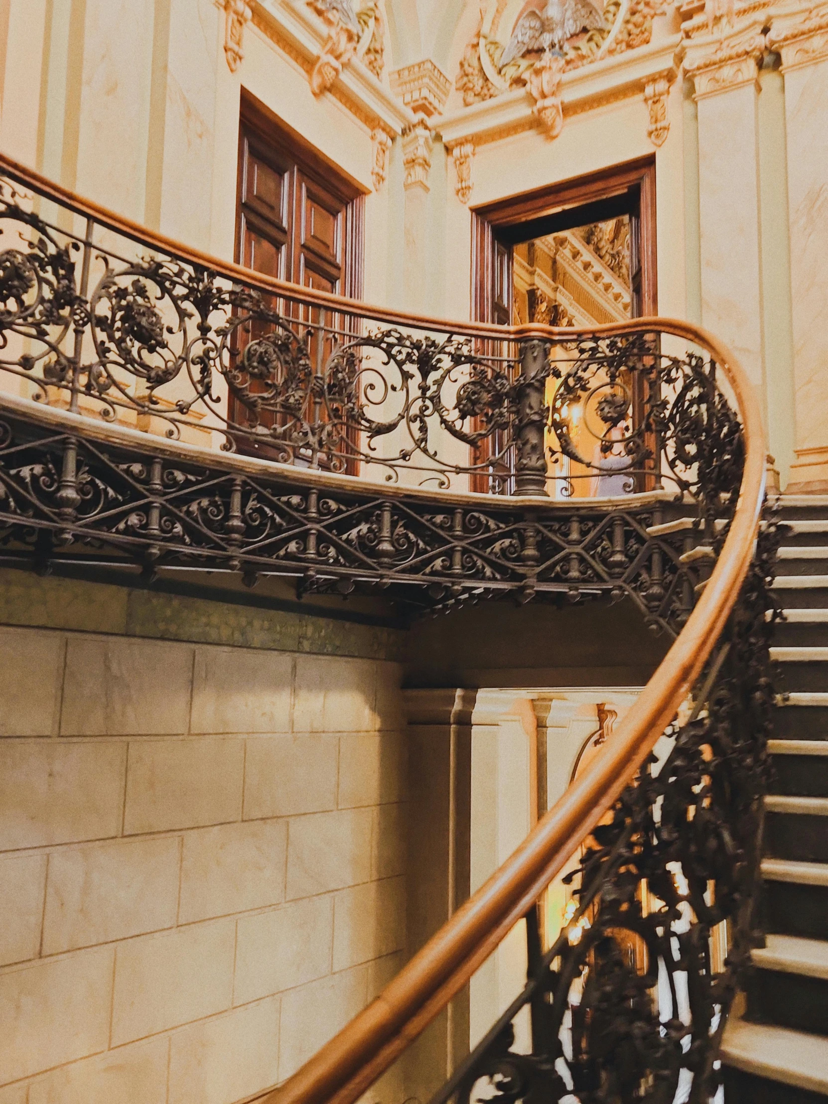 ornately designed staircase in front of ornate painted stone walls