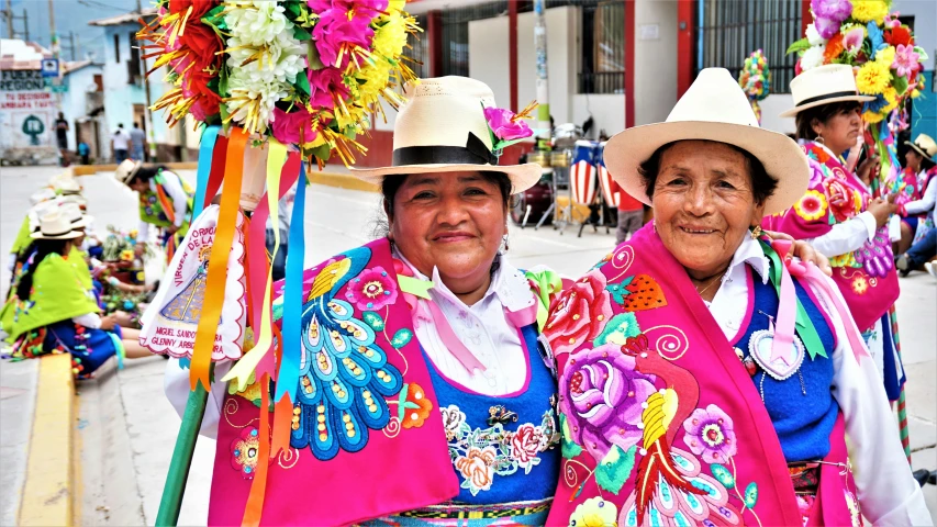 two woman wearing costumes stand under decorations