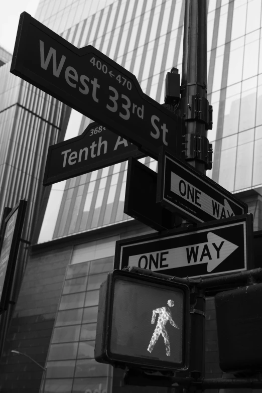 several street signs and traffic lights on a pole