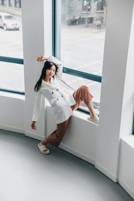 a young lady leans on a wall and poses