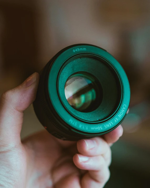a person is holding a lens in front of the camera