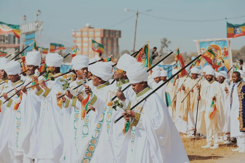 several men in white robes holding flags with the words kingdom of india