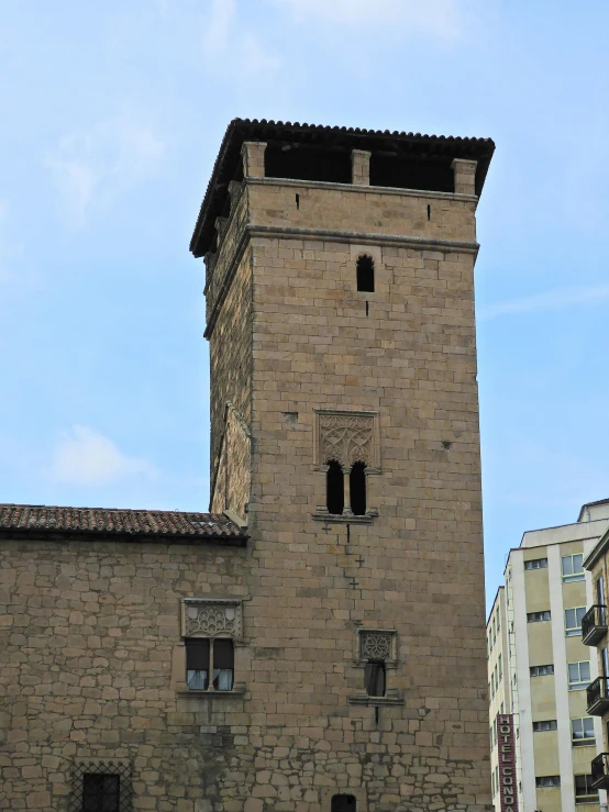 a tall brick tower with an iron roof and windows