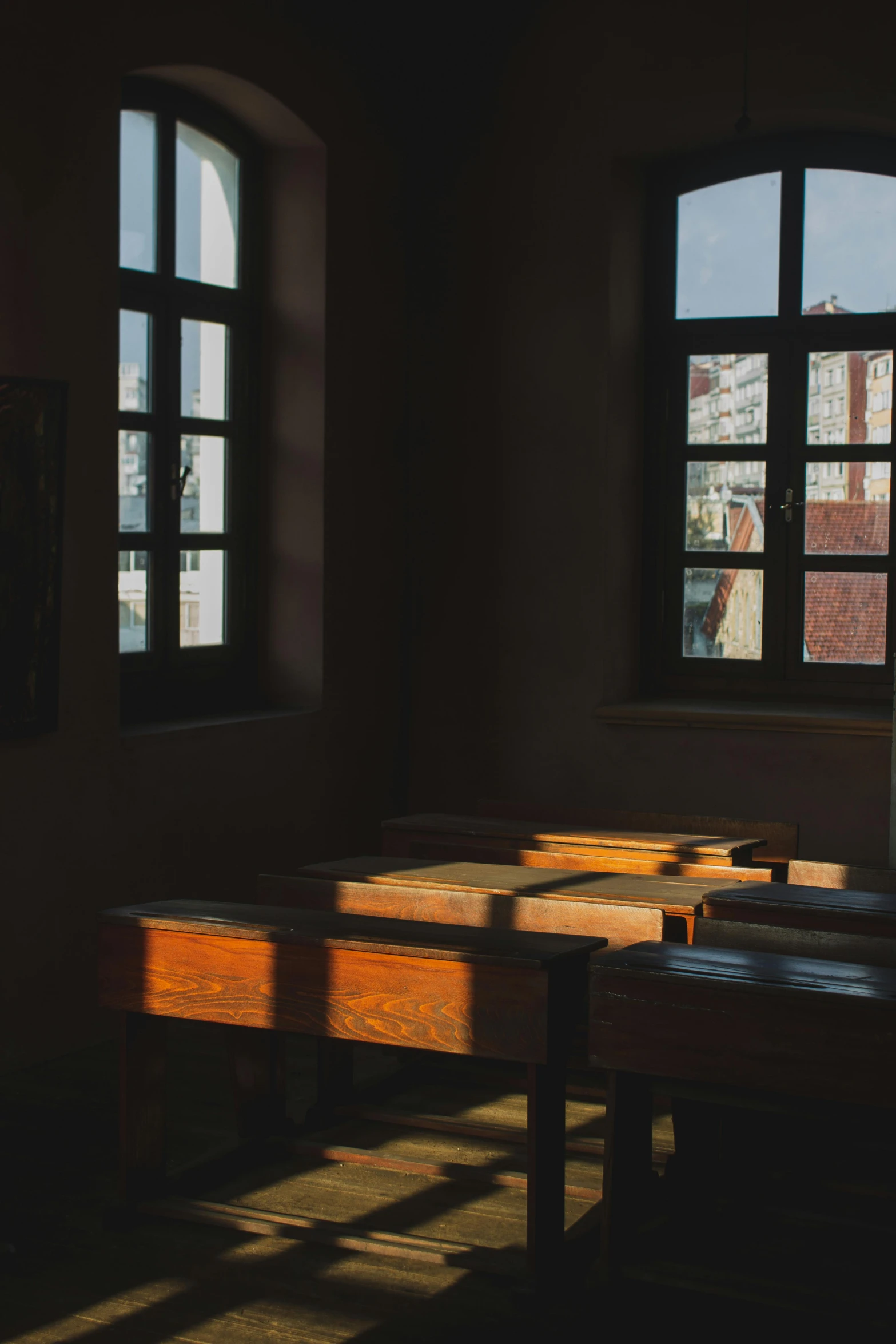 some tables in front of two windows near one another