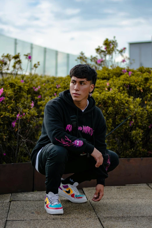 a boy with white sneakers is kneeling down outside