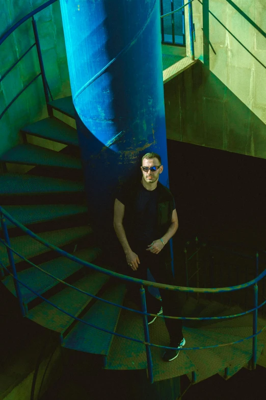 a man is standing at the bottom of a spiral staircase