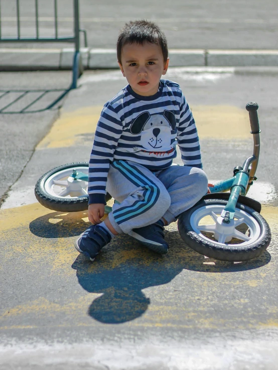 a boy is sitting on a bike in the middle of the street