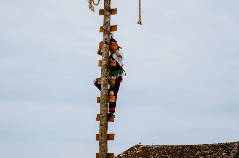 a man that is standing on a pole