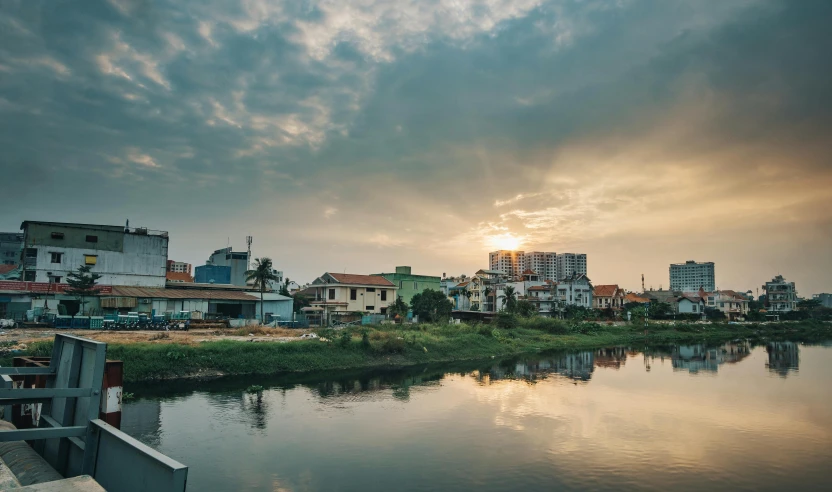 a body of water sitting between a city and a forest