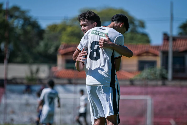 two soccer players hugging and having fun