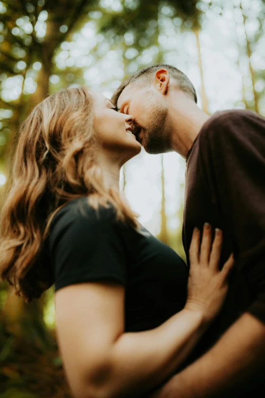 a beautiful woman standing next to a man in the woods