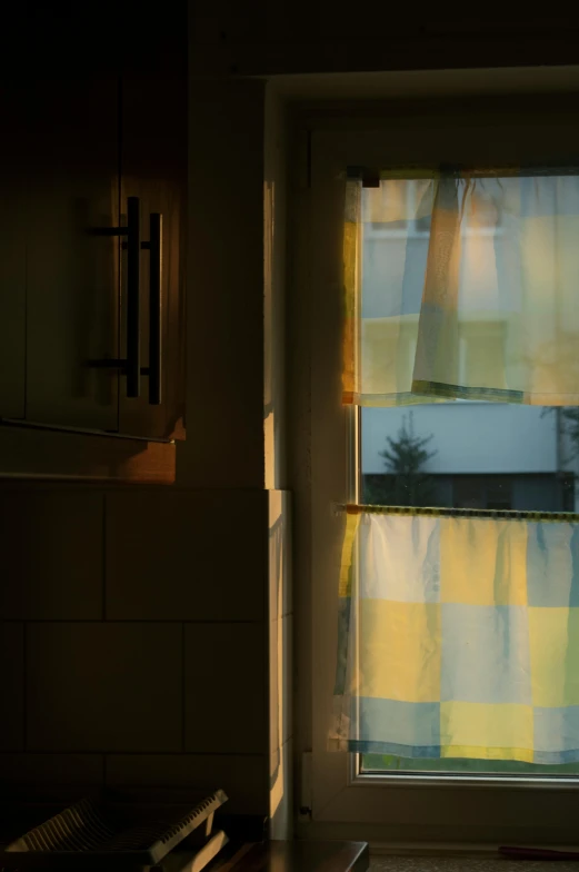 a window with yellow blinds in the evening