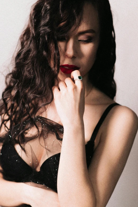 a woman with curly hair wearing black  posing for the camera