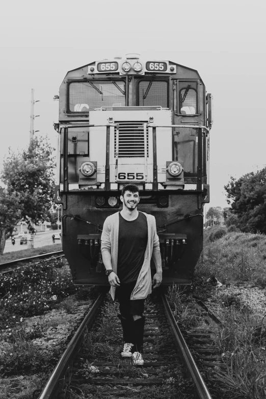 a man stands next to the tracks as the train arrives