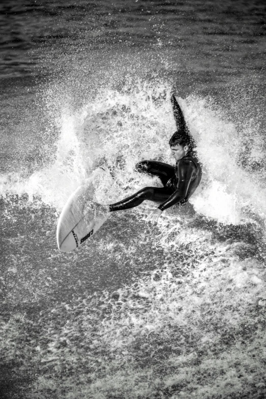 black and white pograph of a surfer trying to catch the wave