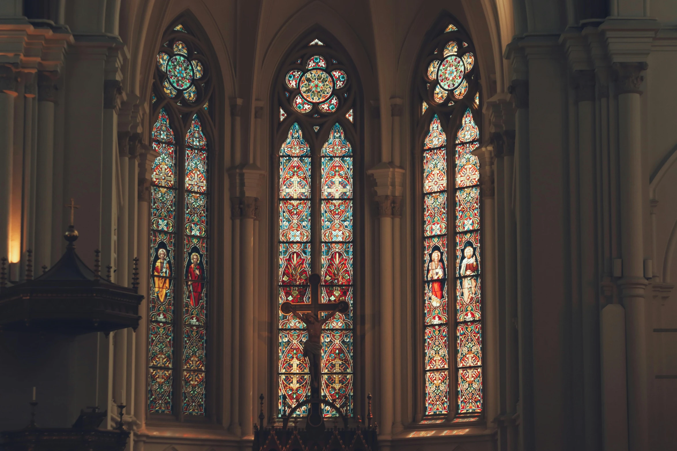 the two tall stained glass windows have a light pouring from them