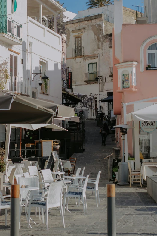 several tables and chairs outside next to a city street