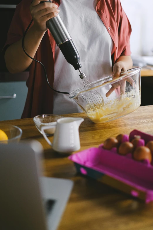 a woman is mixing food with a blender