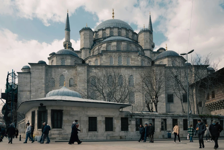 people walking in front of an ancient building