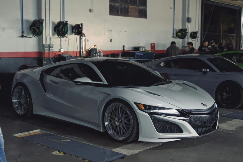 several silver sports cars parked in a parking garage