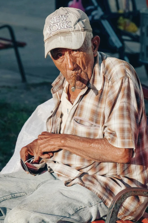 an old man sitting on a bench knitting