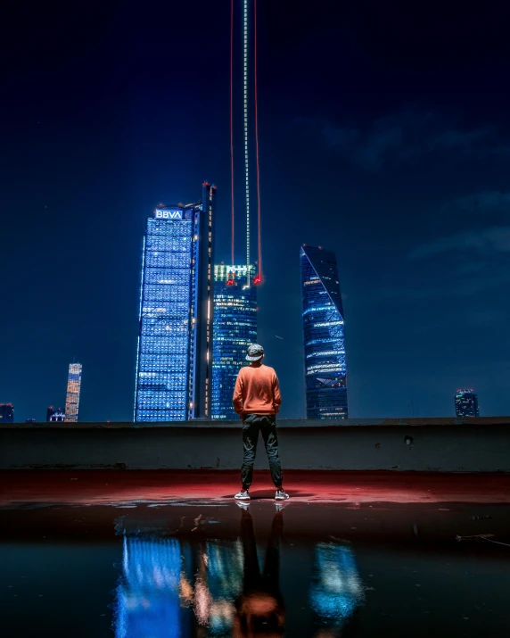 a man with his head turned at night looking out to the city