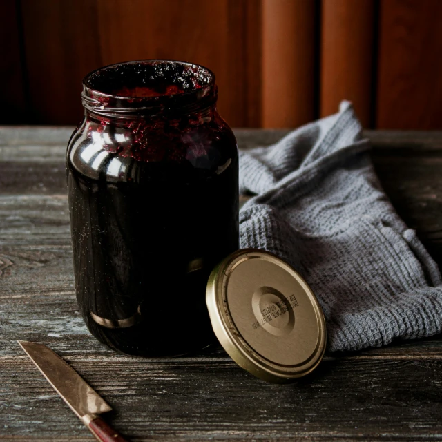 a bottle is sitting on a table with some cloth and a pair of scissors