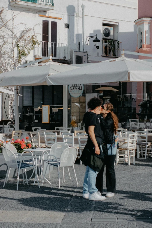 an adult and a child emce in front of a large white tent on the street