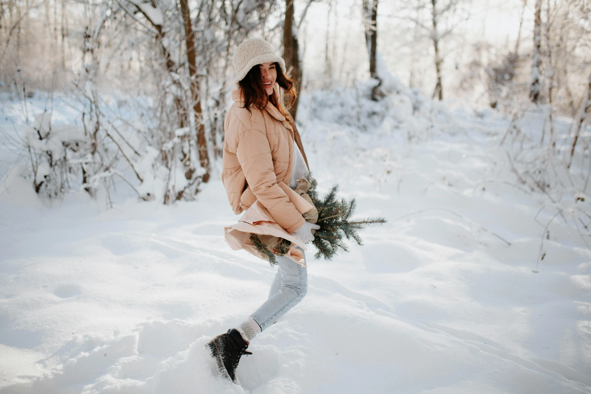 the woman is walking in the snow wearing a hat