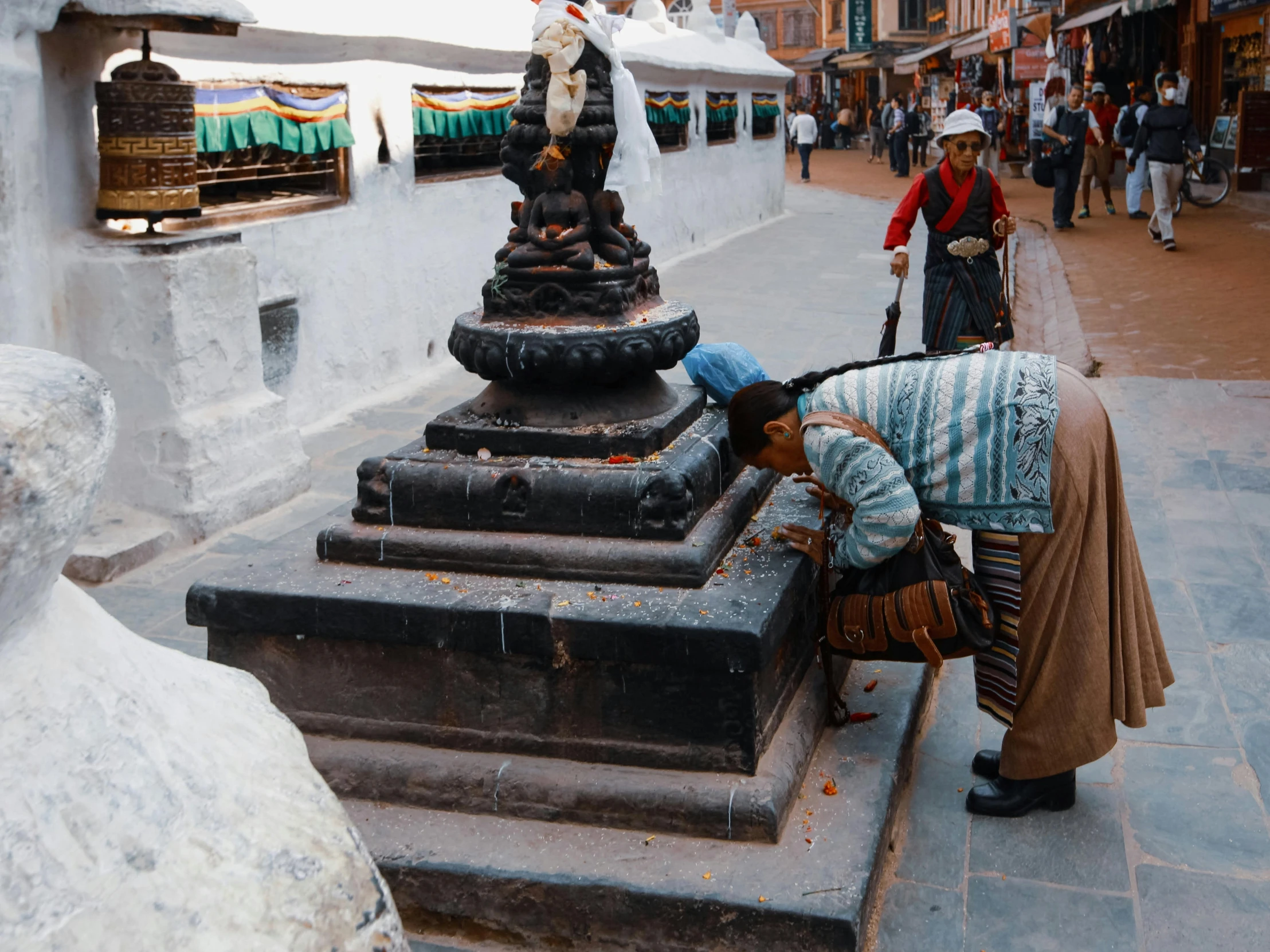 a woman cleaning the base of an ornate water fountain