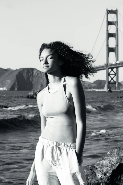 woman with long hair posing on a rock overlooking a large body of water