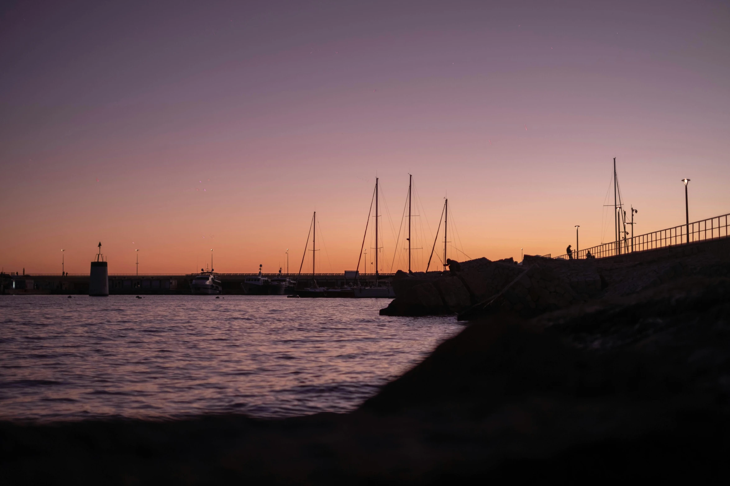 boats in the harbor at sunset as they pass by