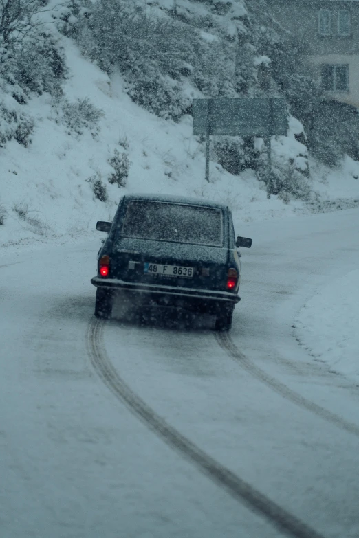 a car on a snowy road with snow in the back