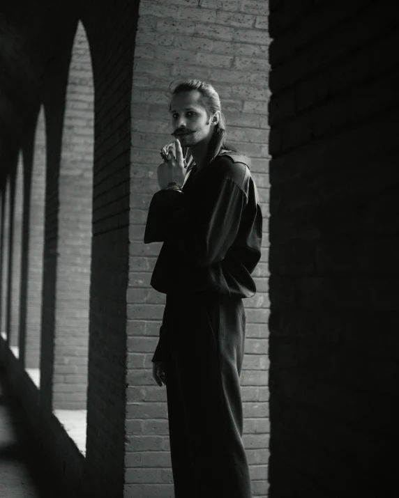 a man is standing outside in a black coat