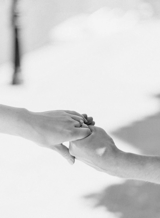 two people with their hands together on a bed