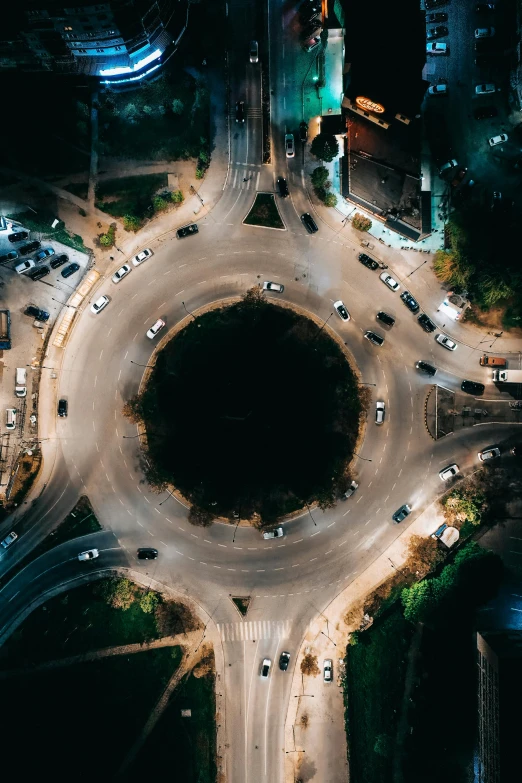 an overhead view of many cars going in and out of the street