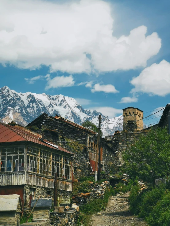 a clock tower near a road surrounded by mountains