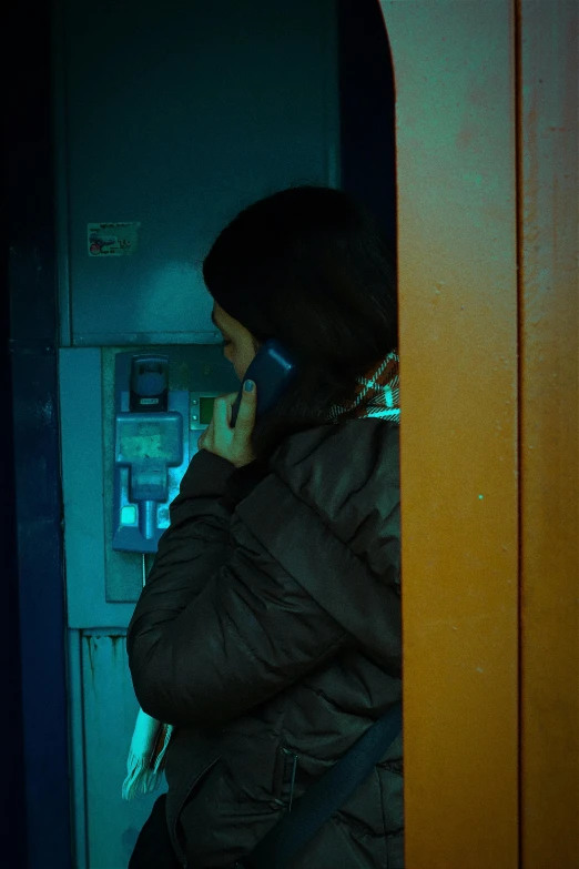 a person is on their cell phone standing by a fridge