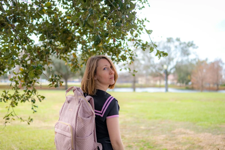 the young woman is carrying a large pink backpack