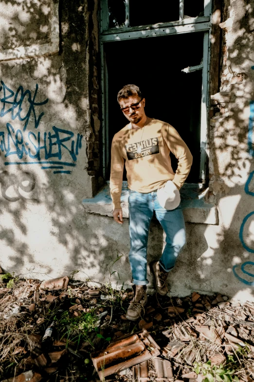 a man standing by a window with graffiti all over the walls