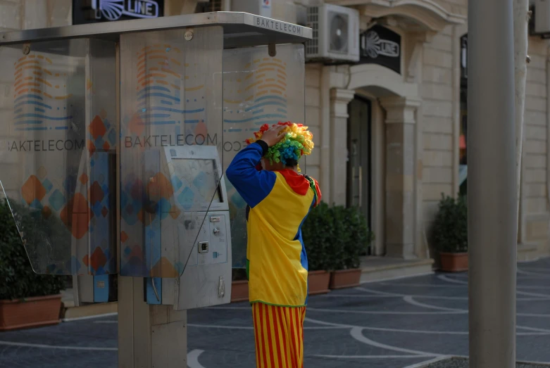 a clown standing in front of a parking meter